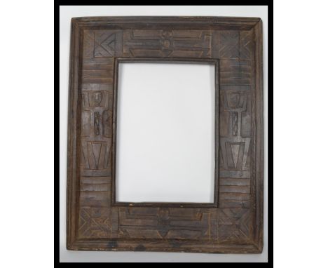 A vintage 20th century hard wood carved African picture frame, the frame heavily carved with African tribal symbolic symbols.