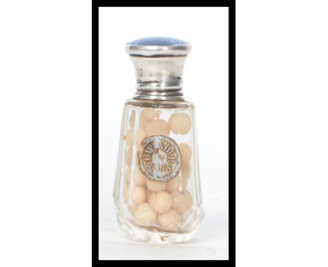 A hallmarked silver and cut glass smelling salts pot having an enamel lid. Complete with original contents and label reading 