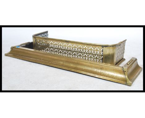 Two 19th century brass fire fenders. One of grille form having pierced decoration and the other of sloped form with arrow cor