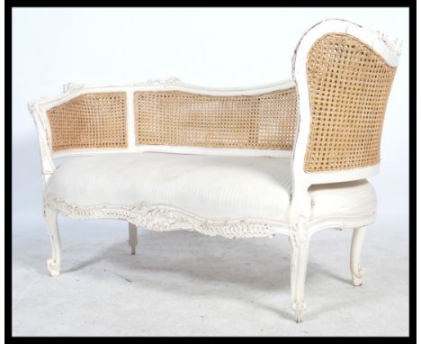 A good 20th century French window seat / loving sofa having bergere caned upright back rest, white linen fabric and turned le