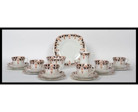 A late 19th / early 20th century bone china tea service in an Imari style pattern, consisting of cups, saucers, creamer, suga