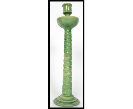 A 19th century Majolica candlestick in the manner of Minton's raised on a stepped circular base with twist column and shaped 