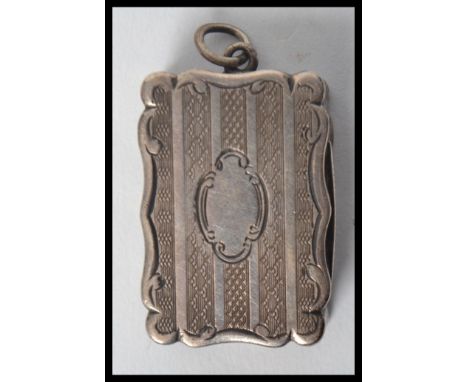 A Victorian hallmarked silver vinaigrette of shaped rectangular form with overall engine turned decoration, with scroll motif