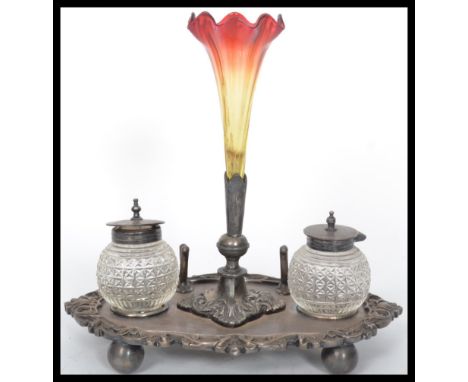 A silver plated desk tidy / ink well having a central glass epergne ruby glass pen holder flanked by cut glass lidded ink wel