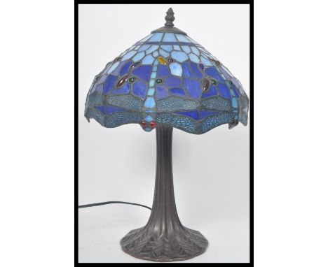 A vintage Tiffany style leaded glass table lamp having a naturalistic style base with stained coloured glass shade. Measures 