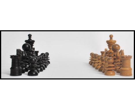 An early 20th century ebony and boxwood chess set of turned form, damage to one black knight. Measures 10cms highest.