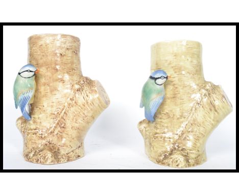 A pair of Sylvac pottery vases modelled with blue tits perched on a tree trunk, no 688, impressed marks to the base. Measures