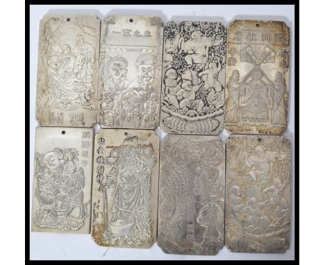 A collection of eight Chinese white metal amulet / scroll weights, cast in relief with various images each piece with makers 
