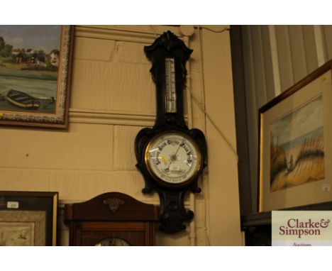 A carved oak aneroid barometer / thermomteer