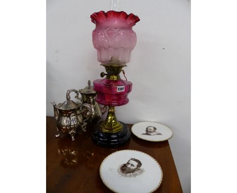 A VICTORIAN OIL LAMP WITH CRANBERRY GLASS RESERVOIR AND CONFORMING ETCHED SHADE AND BRASS DUPLEX BURNER TOGETHER WITH SILVER 
