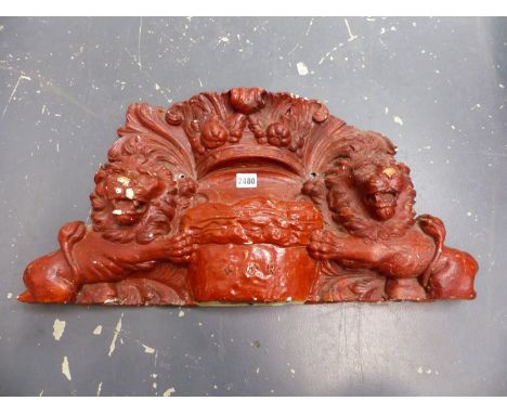 A RED PAINTED PLASTER ARMORIAL CREST SUPPORTED BY LIONS BELOW A CROWN AND FLANKING A CUSHION INSCRIBED M O R.   W.65cms.