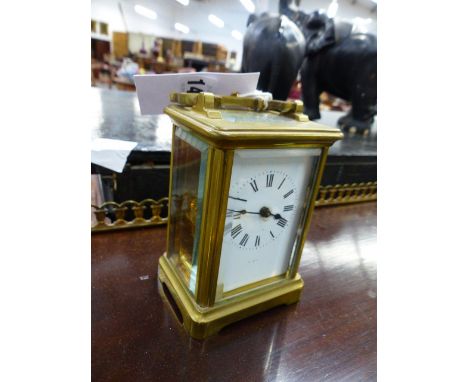 AN EARLY 20th.C.BRASS CASED CARRIAGE CLOCK WITH WHITE ENAMEL DIAL AND SIGNED MOVEMENT.