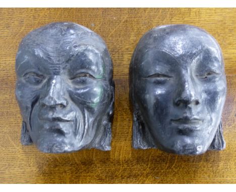 A PAIR OF LEAD MASKS OF A MAN AND A WOMAN IN THE ART DECO TASTE.   H.17cms.