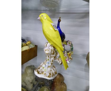 A ROYAL WORCESTER YELLOW CANARY PERCHED ON A TREE TRUNK.   H.17cms TOGETHER WITH A PEACOCK AND FLOWER ENCRUSTED SPILL VASE.  