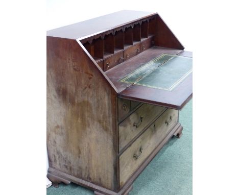 AN UNUSUAL GEORGIAN SLANT TOP BUREAU OF GENEROUS PROPORTIONS WITH FITTED INTERIOR OVER THREE ALIGNED AND TWO LONG DRAWERS ON 