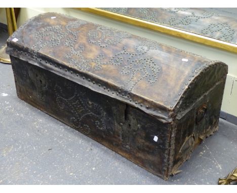 AN EARLY DOME TOP TRUNK WITH VELLUM AND BRASS STUDDED DECORATION.