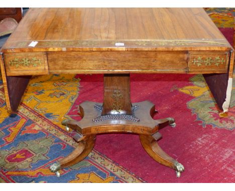 A REGENCY ROSEWOOD AND BRASS INLAID SOFA TABLE ON SHAPED SQUARE COLUMN AND SABRE LEGS WITH BRASS CASTORS.  THE TOP  146 x 66 