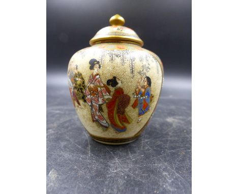 ATTRIB TOKIZAN, A SATSUMA JAR AND COVER PAINTED ON ONE SIDE WITH THREE LADIES SEATED BY A LAMP WITH THEIR FEET COOLING IN A S