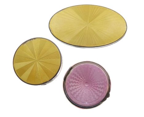 Two early 20th Century white metal and enamel compacts, one with pink enamel, the other yellow, 50mm and smaller, together wi