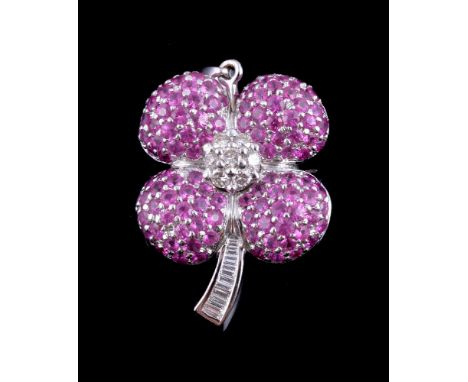 A ruby and diamond flower brooch/pendant, the petals set with circular cut rubies, approximately 3.34 carats total, surroundi