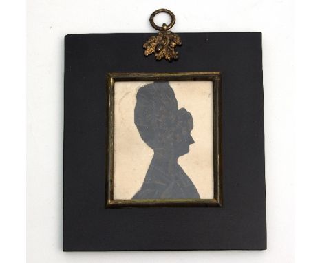 A Regency silhouette bust portrait of a lady, wearing a ribboned bonnet, 7.5cm x 6cm, in a papier-mâché frame, 13.5cm x 12cm