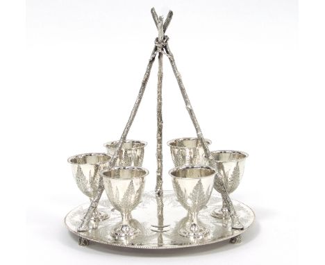 A Victorian silver egg cup stand and six egg cups, Fenton Brothers, Sheffield 1874, the tripod handle of naturalistic form to