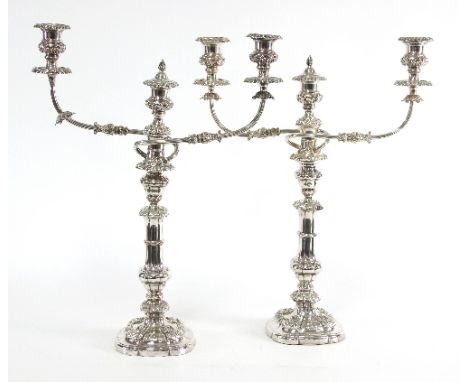 A pair of two-branch three-light plated candelabra, each with scrolling arms and foliate rims, 51cm high/see illustration