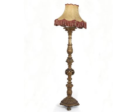 A carved gilt wood standard lamp on paw feet with shade, 170cm high