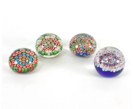 A group of four playing card style glass paperweights, the canes decorated with the various suits, of varying sizes