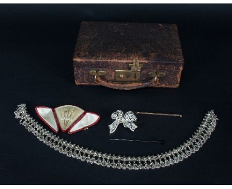 A leather jewellery box containing an Indian silver fringe necklace marked PAR, a paste set ribbon brooch, two small pins and