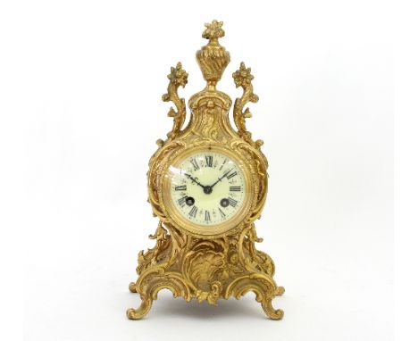 A gilt metal eight-day mantel clock in a Rococo style case, striking on a bell, 35cm high and a pair of two-branch table ligh