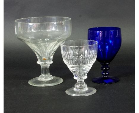 A large Georgian glass rummer with moulded ogee bowl on a circular base, 18cm high, a fluted rummer, 13cm high and a blue gla