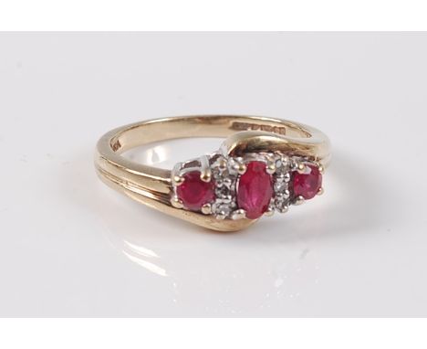 A 9ct ruby and diamond ring, the three graduated oval rubies interspersed with two small round diamonds, all set in white met