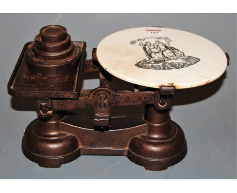 A set of early 20th century iron grocer's scales and weights having ceramic circular plate