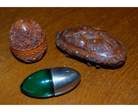 A carved coquilla nut together with an egg shaped pocket snuff box, and one other pocket snuff box