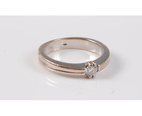 A single stone diamond ring, the round brilliant cut diamond, estimated approx. 0.20cts, claw mounted to narrow reeded should
