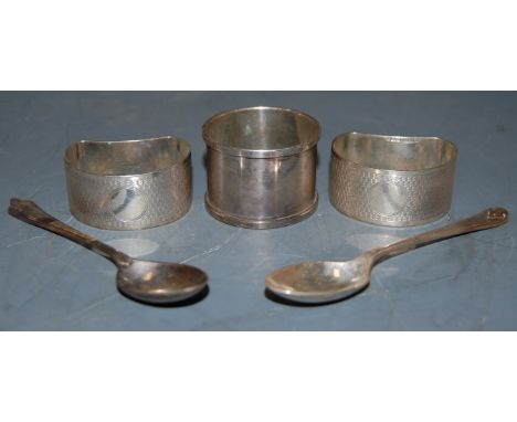 A pair of George V silver kidney shaped napkin rings, having engine turned decoration; together with a further silver napkin 