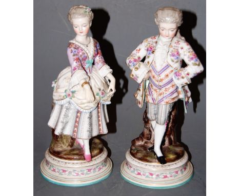 A pair of circa 1900 Continental porcelain figural lamp bases, each in the 18th century style, decorated in bright enamels an