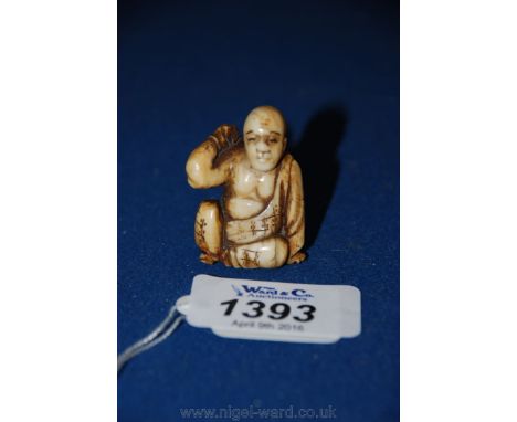 An unusual weighted Meiji Netsuke figure of a seated figure with backscratcher.