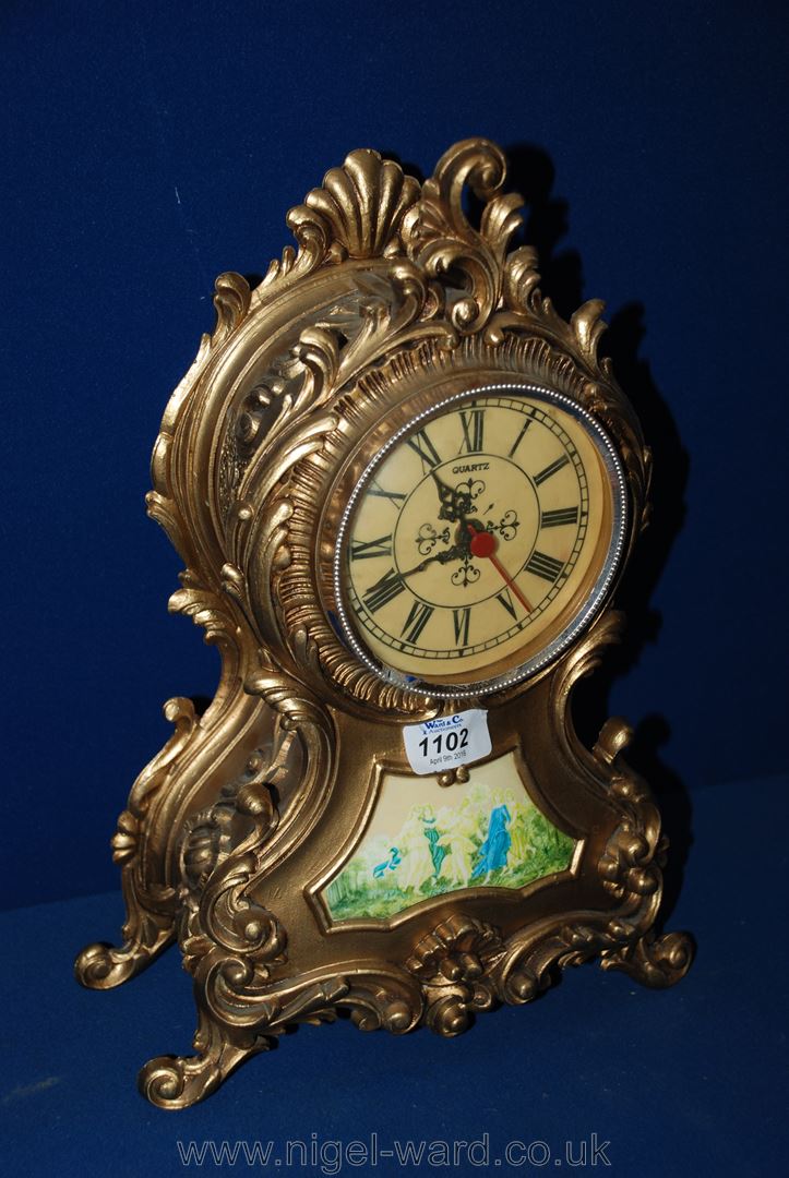 A reproduction gold coloured French style Mantle Clock with ornate Rococo style case and cream co