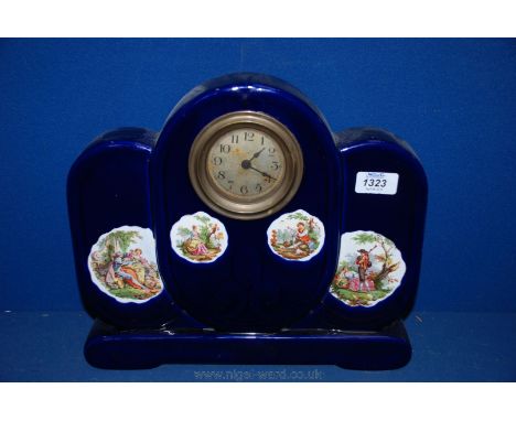 A large blue ceramic Continental style Mantle Clock, centrally mounted clockwork movement over four country scenes of ladies 