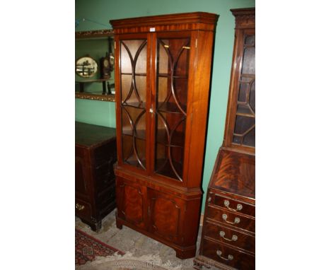 A reproduction Georgian style floor standing four door Corner Cabinet with moulded cornice over upper opposing pair of seven 