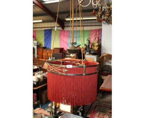A circular rise and fall Dining room Pendant Light fitting with maroon fabric drape and fringe