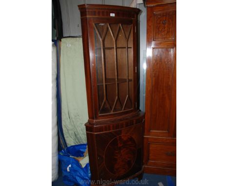 A reproduction Mahogany finished Georgian style Corner Cabinet, having moulded cornice over nine pane glazed upper door, open