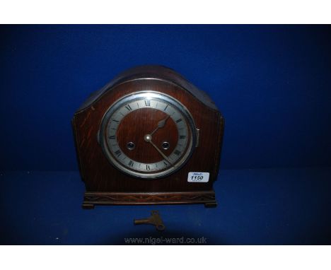 A wooden cased Mantel Clock with pendulum and key.