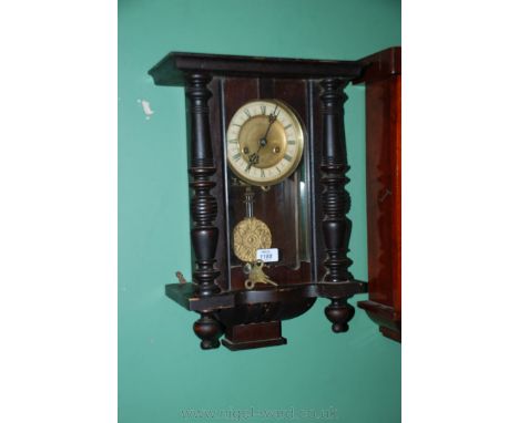 A Victorian stained Pine and Mahogany Vienna Wall Clock, having moulded top over single pane glazed door with applied half tu