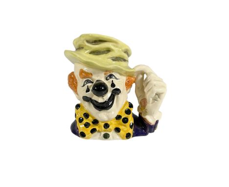 Rare hand painted figural jug of a happy clown with black lipstick and nose. Wearing a light green hat, dark purple coat with
