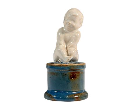 Glazed slip cast buff stoneware figure modeled as a seated child on unusual colored base. Model no. H48. Incised H48, EW to b