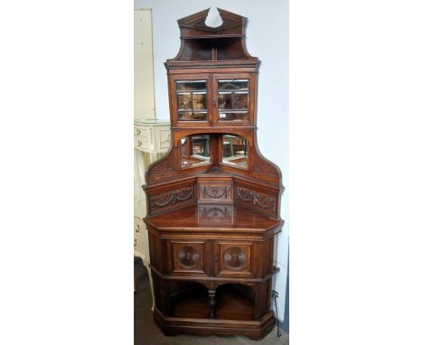 A rosewood corner cabinet with finely carved panels and swag and bow decoration, circa 1900 with retailer's label for George 
