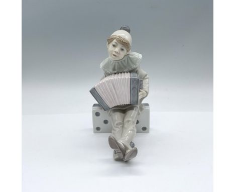 A glossy figure of a young Pierrot seated on a large domino tile, playing the accordion. Lladro backstamp. Artist: Juan Huert